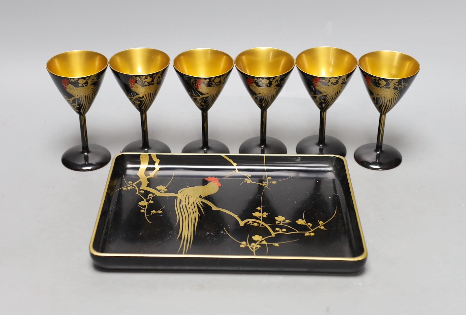 A set of six Japanese lacquer cocktail or liqueur cups and a similar tray